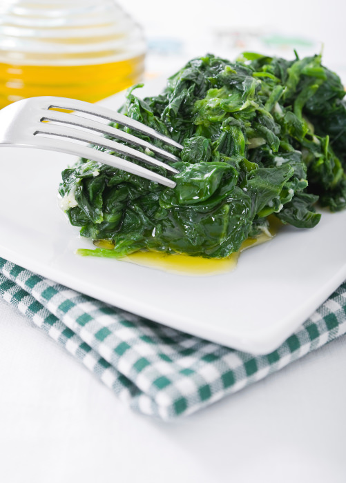 Boiled spinach on white dish.