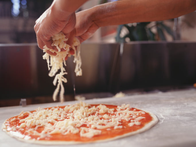 Man making pizza on table, close-up, surface view