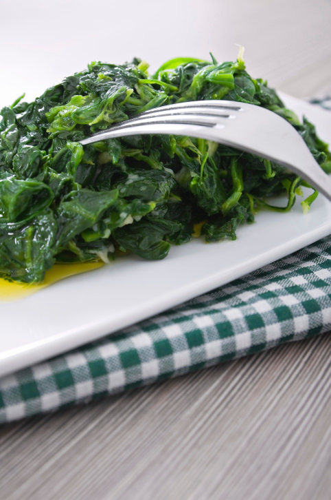 Boiled spinach on white dish.