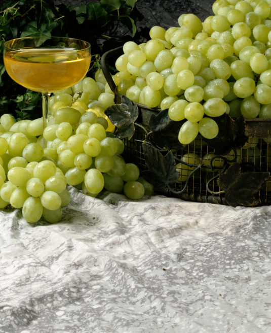 Bunch of grapes near a glass of wine