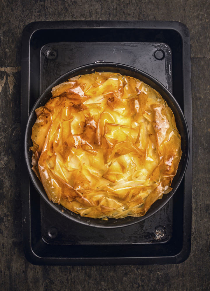 golden Filo pastry pie on black baking tray, top view