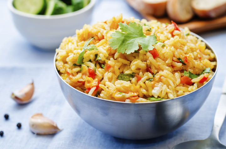 saffron rice with vegetables and cilantro on a blue background. the toning. selective focus