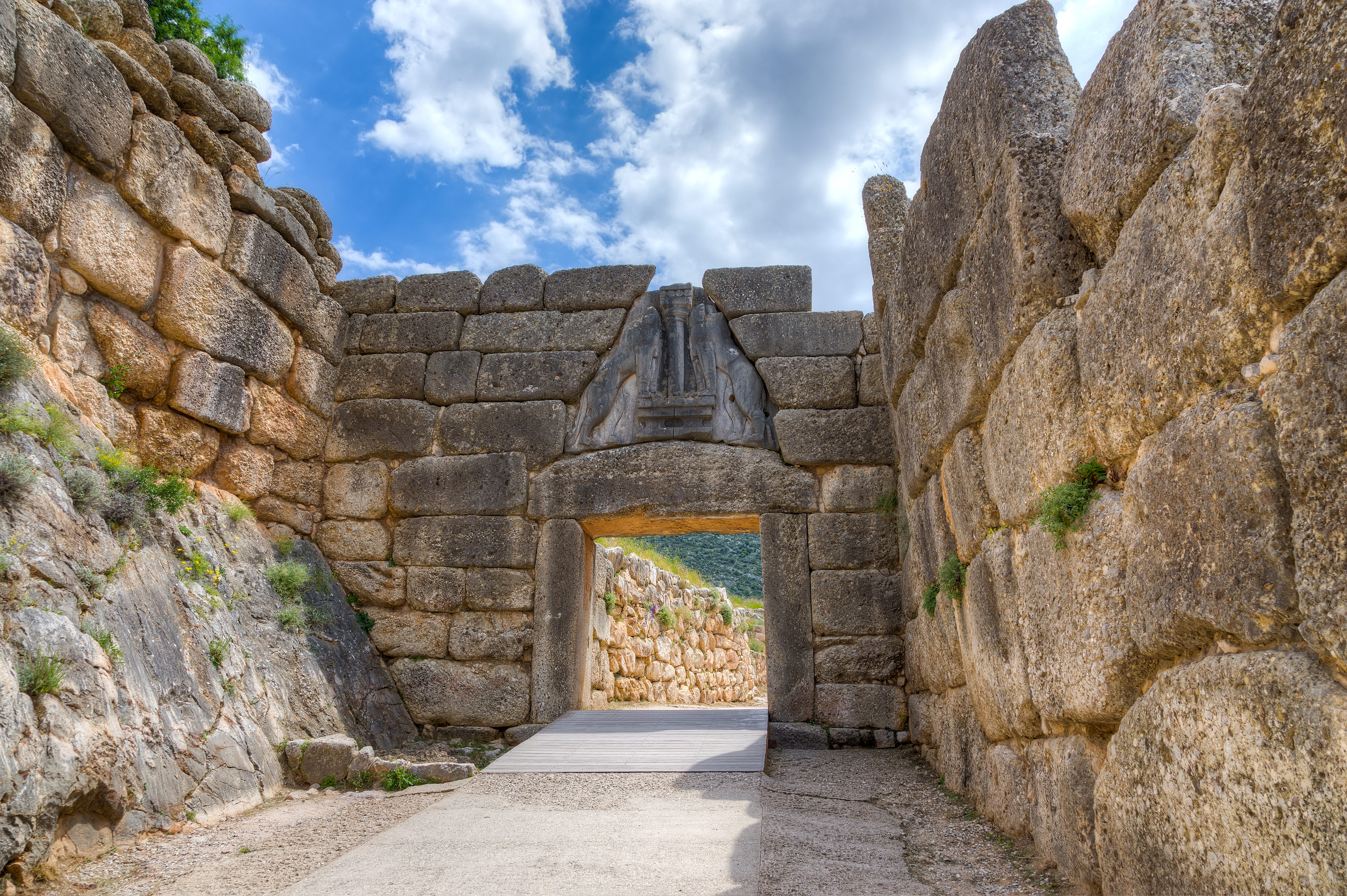 The Lion Gate was the main entrance of the Bronze Age citadel of Mycenae, southern Greece. It was erected during the 13th century BC in the northwest side of the acropolis and is named after the relief sculpture of two lionesses in a heraldic pose that stands above the entrance. The Lion Gate is the sole surviving monumental piece of Mycenaean sculpture, as well as the largest sculpture in the prehistoric Aegean.