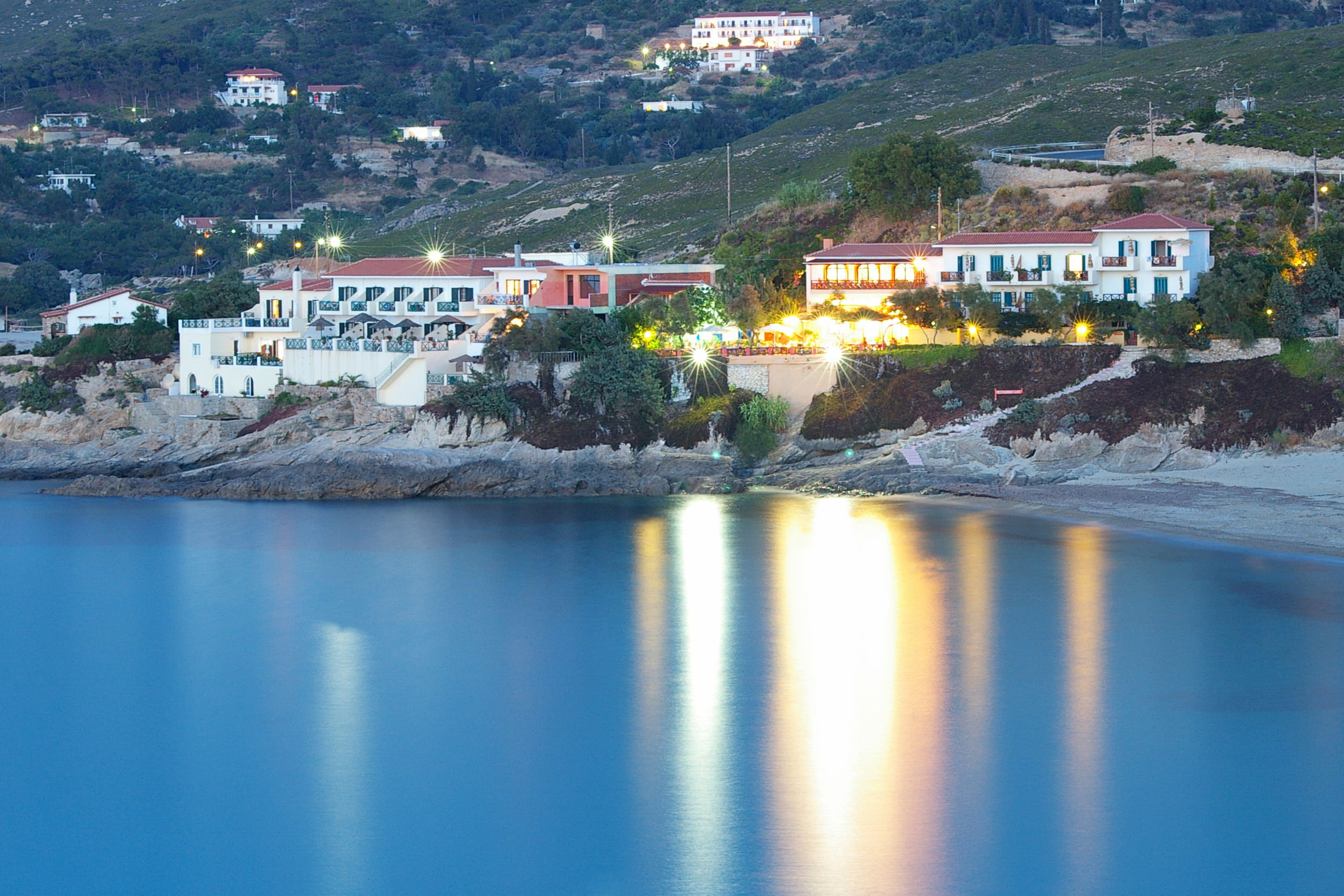 A beautiful Greek village by night and the reflection in the Aegean sea