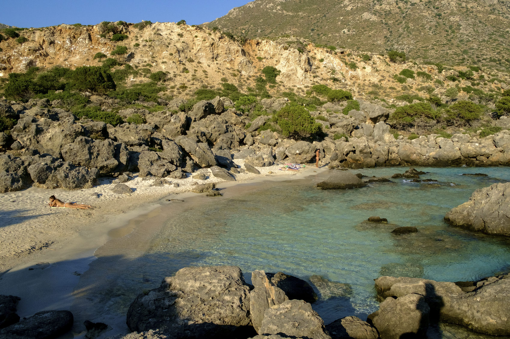 A woman is sunbathing at the shore of a scenic beach at the west part of Chania, near Elafonisi