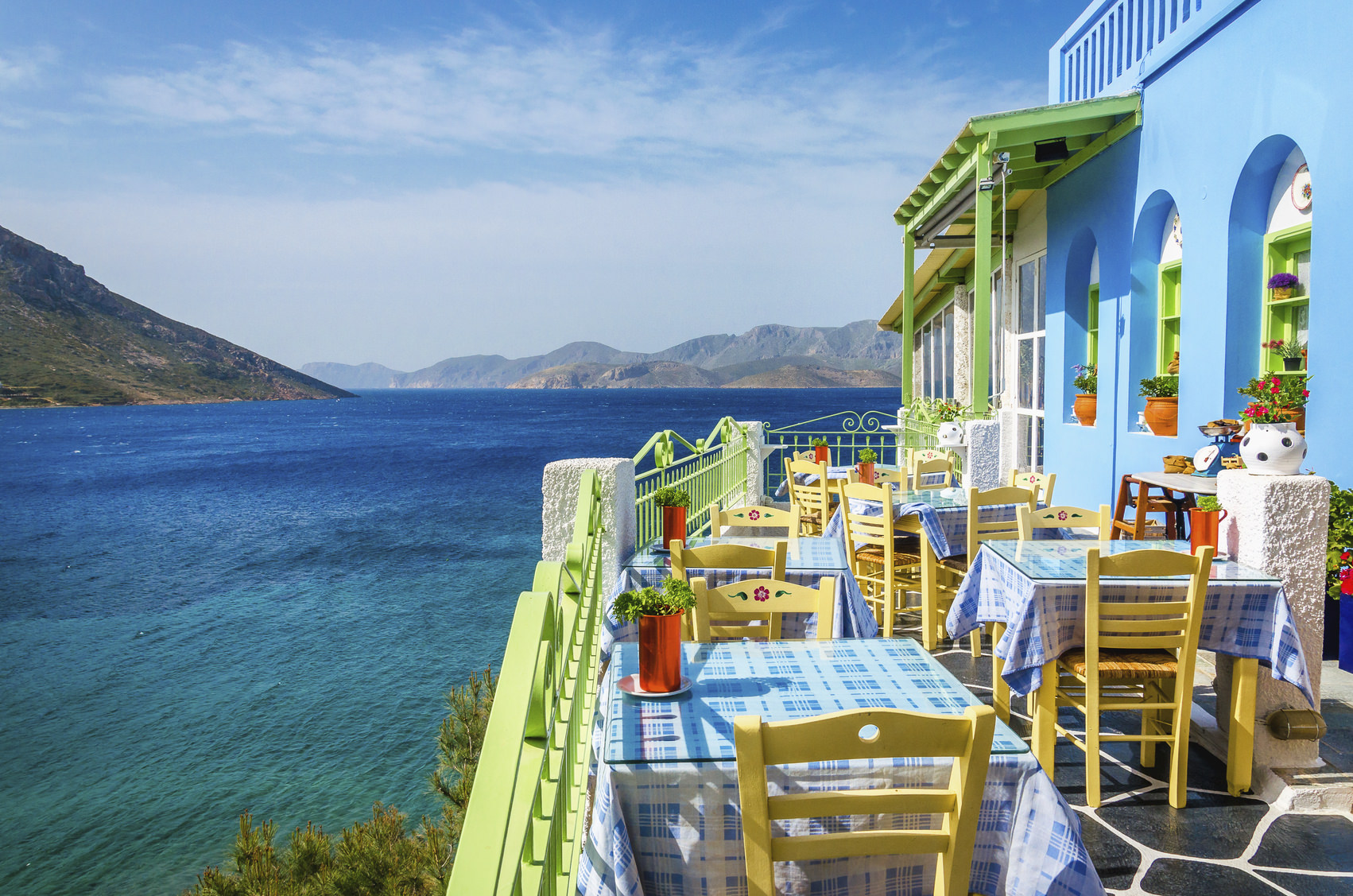 Typical Greek restaurant on the balcony blue building overlooking the sea, Greece